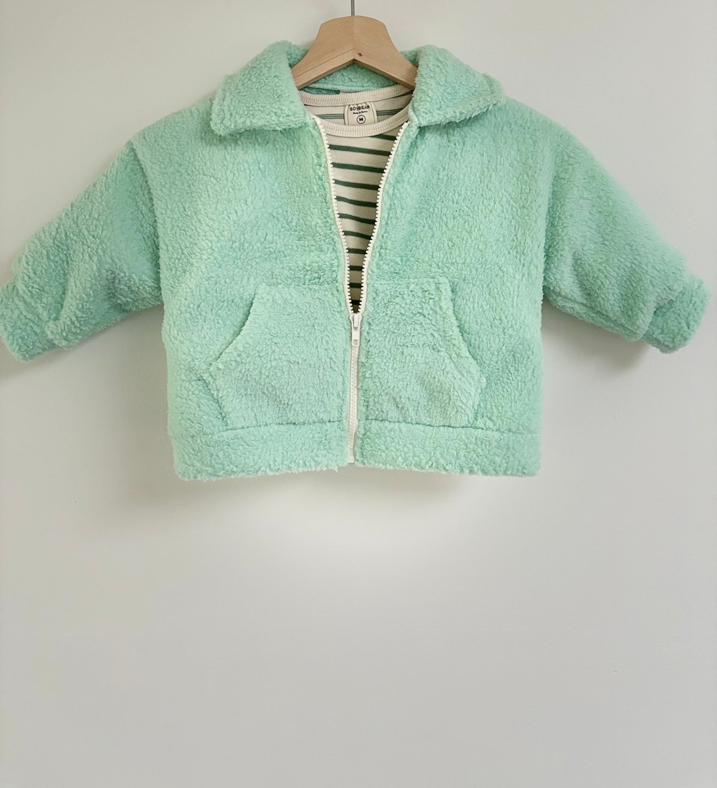 Zachte teddyvest met kraag en witte rits tot onderaan. 